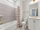 Bright bathroom featuring shower-tub combination and modern vanity with gold fixtures at 11549 Helmond Way # 103, Raleigh, NC 27617