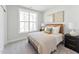 Cozy bedroom featuring a comfortable bed, large window, and neutral decor at 11549 Helmond Way # 103, Raleigh, NC 27617