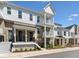 A beautiful exterior view of a modern brick and white townhouse with a cozy porch and balcony at 11549 Helmond Way # 103, Raleigh, NC 27617