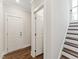 Bright hallway featuring hardwood floors, white doors, trim, and stairs leading to the upper level at 11549 Helmond Way # 103, Raleigh, NC 27617