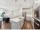 Bright kitchen with modern appliances, an island with bar seating, and a view into the living area at 11549 Helmond Way # 103, Raleigh, NC 27617