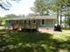 Rear exterior showcasing a light blue house with a new wooden back deck and green grass at 1165 John Mitchell Rd, Youngsville, NC 27596