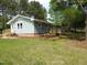 Back exterior featuring light blue siding, a new wooden deck, and views of the backyard at 1165 John Mitchell Rd, Youngsville, NC 27596