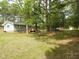 Large back yard featuring a well-maintained lawn, tall trees, and a view of the back of the house at 1165 John Mitchell Rd, Youngsville, NC 27596