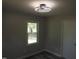 This is a bedroom with a view to the outside through a large window, neutral paint and a ceiling fan at 1165 John Mitchell Rd, Youngsville, NC 27596
