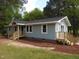 Charming single-story home features light blue siding, a cozy front porch, and a new wooden deck at 1165 John Mitchell Rd, Youngsville, NC 27596