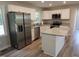 A modern kitchen with stainless steel appliances, white cabinets, and an island with granite countertops at 1165 John Mitchell Rd, Youngsville, NC 27596
