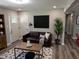 Cozy living room with a comfortable brown sofa, stylish rug, and a modern aesthetic at 1165 John Mitchell Rd, Youngsville, NC 27596