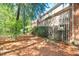 The backyard shows the home's brick exterior and deck overlooking the wooded yard with pine straw ground cover at 12 Innisfree Dr, Durham, NC 27707