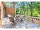 Cozy backyard deck featuring comfortable seating and a glass table surrounded by lush greenery at 12 Innisfree Dr, Durham, NC 27707