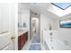 Bright bathroom with a skylight, bathtub, blue rugs, and a charming decor at 12 Innisfree Dr, Durham, NC 27707