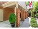 Charming covered carport with brick columns, adjacent to a lush, green garden area at 12 Innisfree Dr, Durham, NC 27707