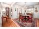Dining room features a round table, chandelier, custom drapery, and wood flooring at 12 Innisfree Dr, Durham, NC 27707