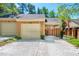 Brick townhome featuring attached garage, carport, and American flag at 12 Innisfree Dr, Durham, NC 27707