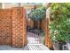 Brick courtyard gate featuring decorative metalwork, leading to the private outdoor space at 12 Innisfree Dr, Durham, NC 27707