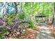 Charming gazebo surrounded by lush greenery and blooming flowers, creating a serene outdoor escape on the property at 12 Innisfree Dr, Durham, NC 27707