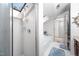 Bright shower with glass doors, white tile, and a skylight, creating a clean and airy space at 12 Innisfree Dr, Durham, NC 27707