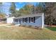 Charming home with blue vinyl siding, dark shutters, landscaped front yard, and a well-maintained lawn at 1203 Freeman Dr, Sanford, NC 27330