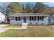 Charming single-story home with blue siding, black shutters, and well-maintained front yard landscaping at 1203 Freeman Dr, Sanford, NC 27330