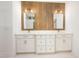 Bathroom with double vanity, white cabinets, wooden accent wall, and rectangular mirrors at 1222 Red Cedar Ct, Youngsville, NC 27596