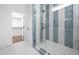Stylish bathroom featuring a glass shower with blue and white tiles and a view into the walk-in closet at 1222 Red Cedar Ct, Youngsville, NC 27596
