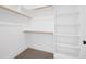 A well-organized walk-in closet with multiple shelves and wooden rods for ample storage at 1222 Red Cedar Ct, Youngsville, NC 27596
