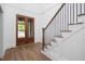 The foyer features wood floors, staircase with black metal railing, and wood double doors at 1222 Red Cedar Ct, Youngsville, NC 27596