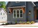 A detailed view of the siding on a gray farmhouse-style home with modern outdoor lighting at 1222 Red Cedar Ct, Youngsville, NC 27596