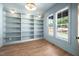 Bright home office or study featuring built-in shelving, wood-look floors, and light gray walls at 1222 Red Cedar Ct, Youngsville, NC 27596