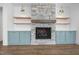 Living room features a stone fireplace with a wooden mantel, built-in shelving, and decorative sconces at 1222 Red Cedar Ct, Youngsville, NC 27596