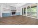 Open-concept living area features a stone fireplace, built-in shelving, and sliding glass doors to the patio at 1222 Red Cedar Ct, Youngsville, NC 27596