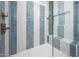 Modern shower featuring blue and white striped tiles, a built-in bench, and a convenient shower niche at 1222 Red Cedar Ct, Youngsville, NC 27596