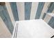 Close-up of shower with stylish blue and white striped tiling and modern shower fixtures at 1222 Red Cedar Ct, Youngsville, NC 27596
