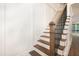 Staircase featuring wood treads, white risers, a wood handrail, and a black metal railing at 1222 Red Cedar Ct, Youngsville, NC 27596