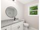 Bathroom with modern vanity, round mirror, and bright window at 124 Strickland Dr, Smithfield, NC 27577