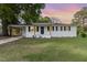 Attractive white brick home featuring a carport, contrasting black shutters, and a lush green lawn at 124 Strickland Dr, Smithfield, NC 27577