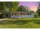 Charming single-story home with white brick and black shutters, complemented by a well-maintained lawn at 124 Strickland Dr, Smithfield, NC 27577