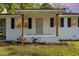 Close-up of the front of a charming white brick home with a covered porch and manicured landscaping at 124 Strickland Dr, Smithfield, NC 27577