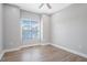 Cozy bedroom featuring hardwood floors, a ceiling fan, and a large window for natural light at 1301 Tawny View Ln, Raleigh, NC 27603