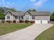 Well maintained home with inviting front porch, manicured lawn, and three-car garage at 1301 Tawny View Ln, Raleigh, NC 27603