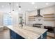 Modern kitchen with a large island, stainless steel appliances, and wooden floating shelves at 1301 Tawny View Ln, Raleigh, NC 27603
