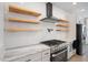 Stylish kitchen showcasing floating wooden shelves, a stainless steel stove, and sleek countertops at 1301 Tawny View Ln, Raleigh, NC 27603