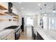 Bright kitchen features marble countertops, stainless steel appliances, floating shelves, and pendant lighting at 1301 Tawny View Ln, Raleigh, NC 27603