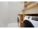Functional laundry room with modern appliances, custom shelving, and tile floor at 1301 Tawny View Ln, Raleigh, NC 27603