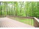 A wood deck overlooks the backyard of this house surrounded by trees at 14 Whit Ct, Angier, NC 27501