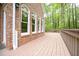 The back of this brick house features a lovely stained wood deck at 14 Whit Ct, Angier, NC 27501
