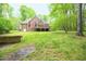 The backyard of this house features lush green grass and lots of trees at 14 Whit Ct, Angier, NC 27501