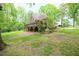 The backyard of this brick house has a large, lush lawn and mature trees at 14 Whit Ct, Angier, NC 27501