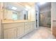 Bathroom featuring double sinks, tile flooring, and glass shower enclosure at 14 Whit Ct, Angier, NC 27501