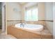 Bathroom featuring a built-in tub with tile surround and large window at 14 Whit Ct, Angier, NC 27501
